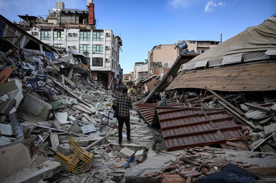 A man walks among the rubble of collapsed buildings after a powerful earthquake in Hatay, southern Türkiye, March 6, 2023. (AFP Photo)