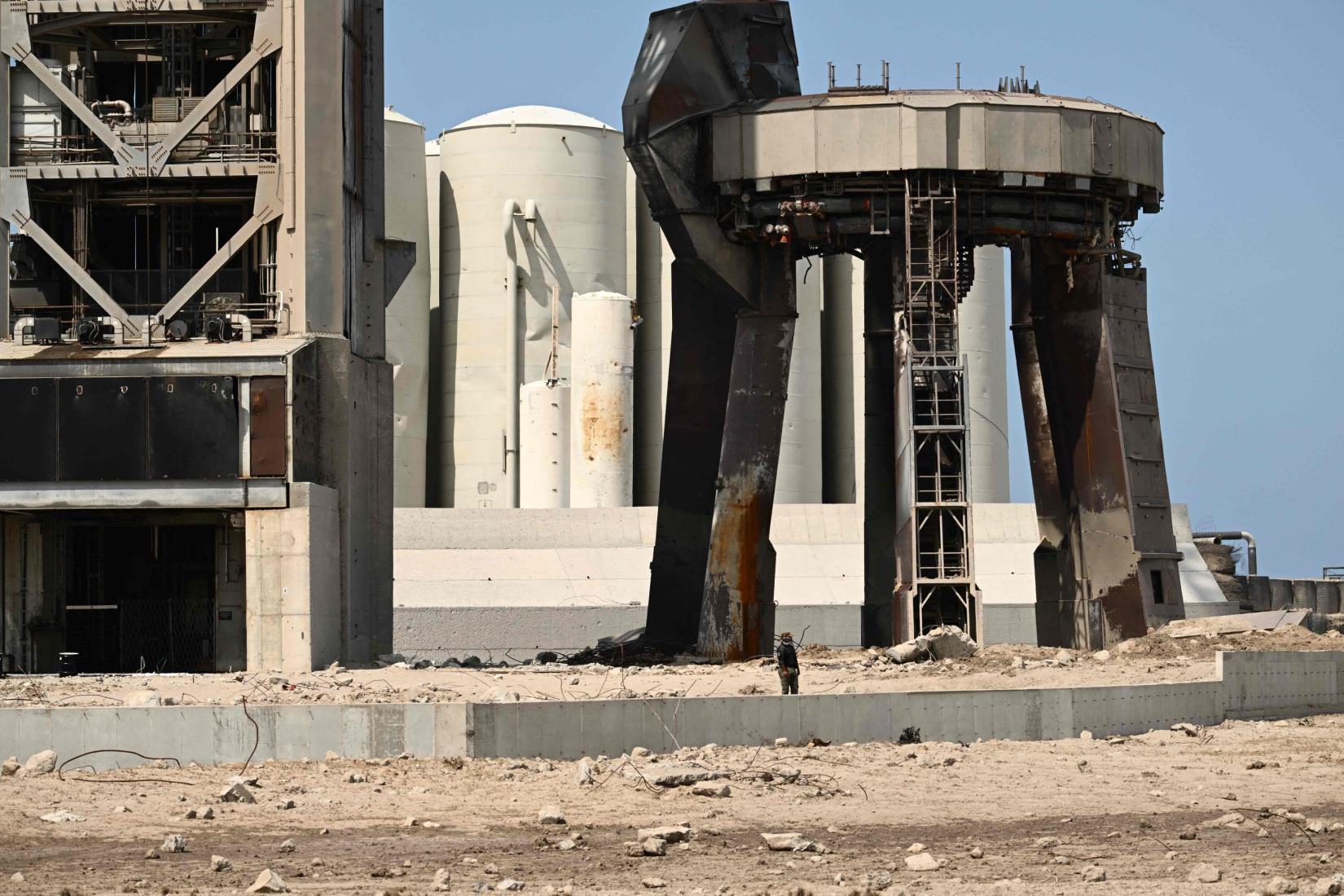 A security guard keeps an eye on members of the public as they walk through a debris field at the launch pad, after the SpaceX Starship lifted off from Starba<em></em>se in Boca Chica, Texas, U.S., April 22, 2023. (AFP Photo)