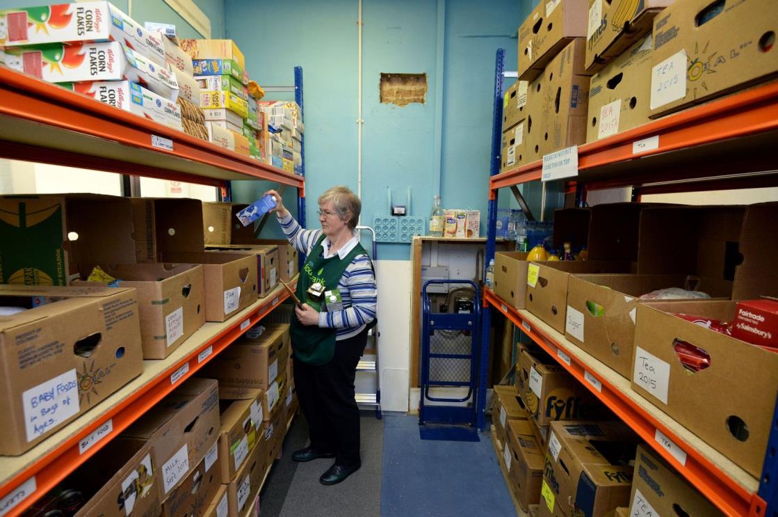 A volunteer helps pick food from the shelves at the Bromley Borough Foodbank, part of The Trussell Trust, in Orpington, London, U.K., April 16, 2014. (Reuters Photo)