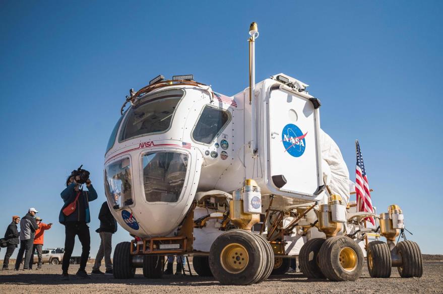 Members of the media stand next to a moon rover prototype for future Artemis missions at the Black Point Lava Flow near Flagstaff, Arizona, U.S., Oct. 24, 2022. (AFP Photo)