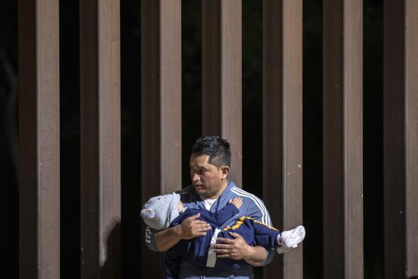 A migrant father holds his son in his arms as he waits to be processed by Border Patrol agents after crossing illegally the border between the United States and Mexico, in Yuma, Arizona, U.S., May 10, 2023. (EPA Photo)