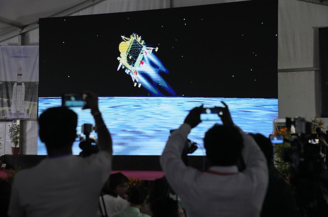 Journalists film the live telecast of spacecraft Chandrayaan-3 landing on the moon at ISRO's Telemetry, Tracking and Command Network facility in Bengaluru, India, Wednesday, Aug. 23, 2023. India lands a spacecraft near the moon’s south pole, becoming the fourth country to touch down on the lunar surface. (AP Photo/Aijaz Rahi)